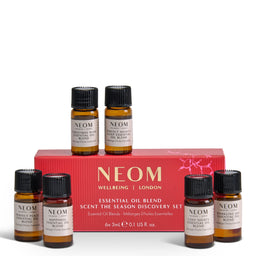 NEOM Wellbeing London Scent the Season Discovery Set, featuring a red gift box and six amber glass essential oil bottles with black caps and cream labels, arranged on a white background.