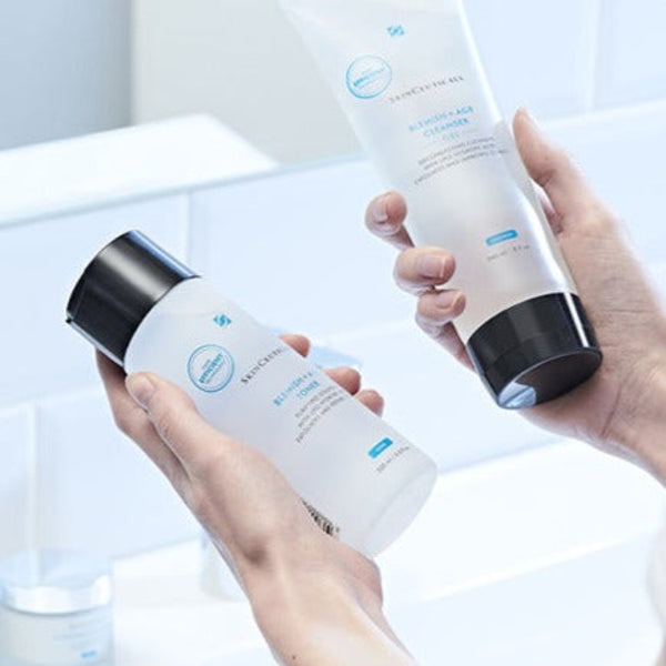 a person holing to bottles of SkinCeuticals Blemish + AGE Toner