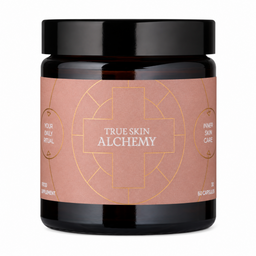 A black supplement jar with a black lid and a dusty rose label featuring gold geometric line art and the text 'TRUE SKIN ALCHEMY' and 'YOUR DAILY ALCHEMY'.