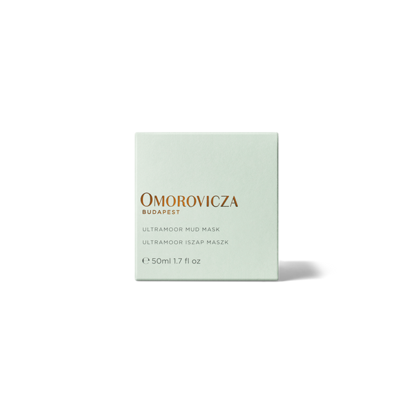 A square, pale mint green box of Omorovicza Budapest Ultramood Mud Mask, featuring gold and black text, centered on a clean white background with a soft shadow.
