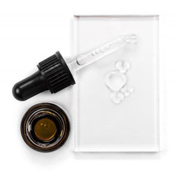 Avant Skincare Advanced Bio Absolute Youth Eye Therapy (Anti-Ageing) with an open lid and its contents poured onto a glass slate
