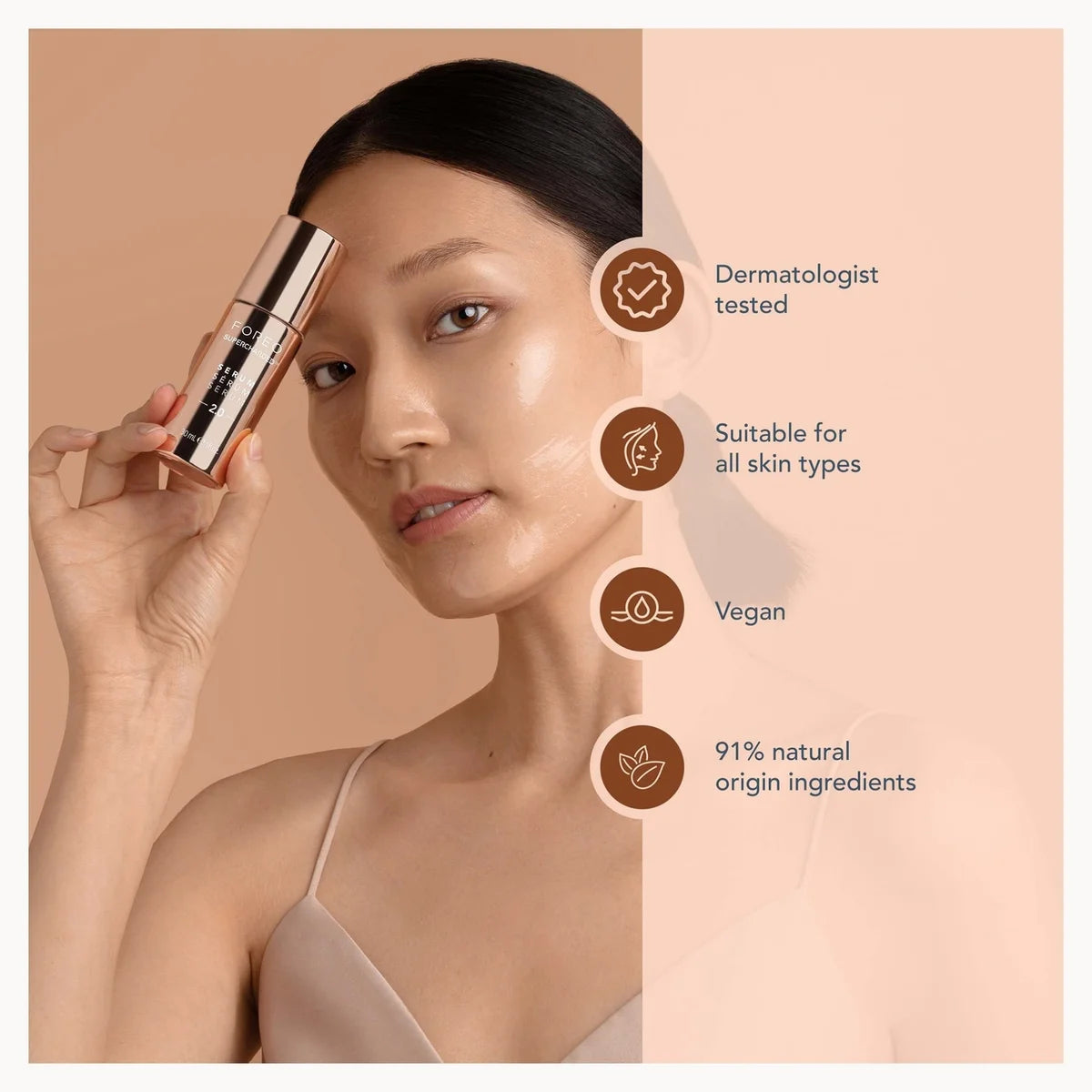 A woman holds a cylindrical cosmetic tube against her cheek on a warm beige background, with text callouts on the right stating dermatologist tested, suitable for all skin types, vegan, and 91% natural origin ingredients.