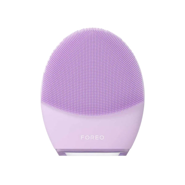 A lavender purple FOREO facial cleansing device with a textured silicone brush head, centered on a clean off-white background.