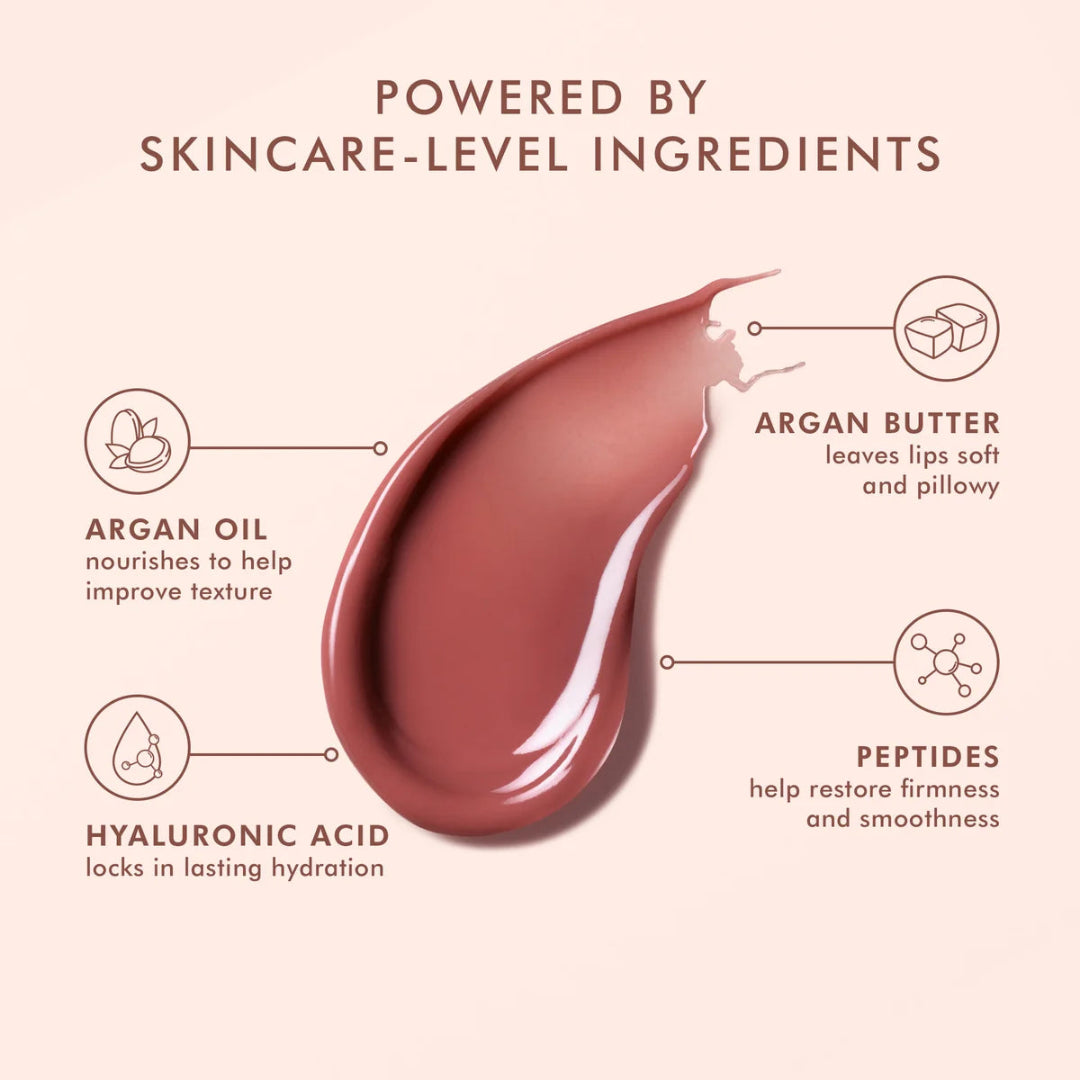 Lip balm droplet with skincare ingredients labeled on a pink background