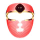 A red silicone facial massage mask with gold trim and a central dark brown plaque featuring the gold 'FAQ' logo, shown on a solid white background.