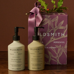 Two Wildsmith skincare bottles with a decorative box on a wooden surface.