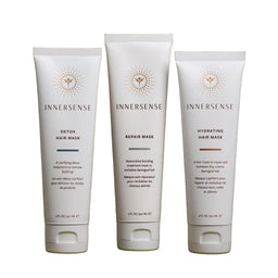 Three Innersense hair mask tubes on a green background
