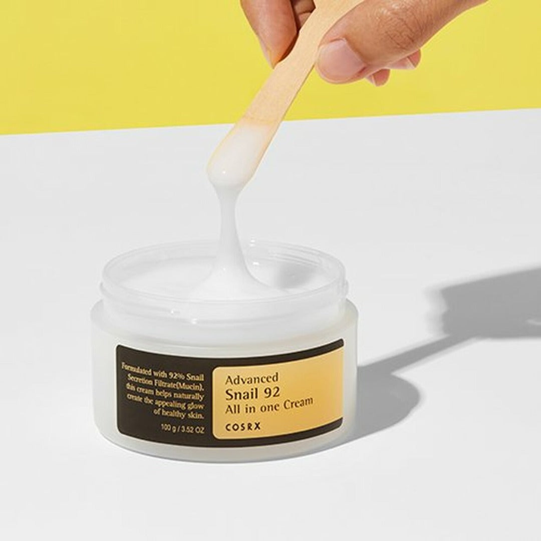 COSRX Advanced Snail 92 All in one Cream being dipped into with a wooden spoon