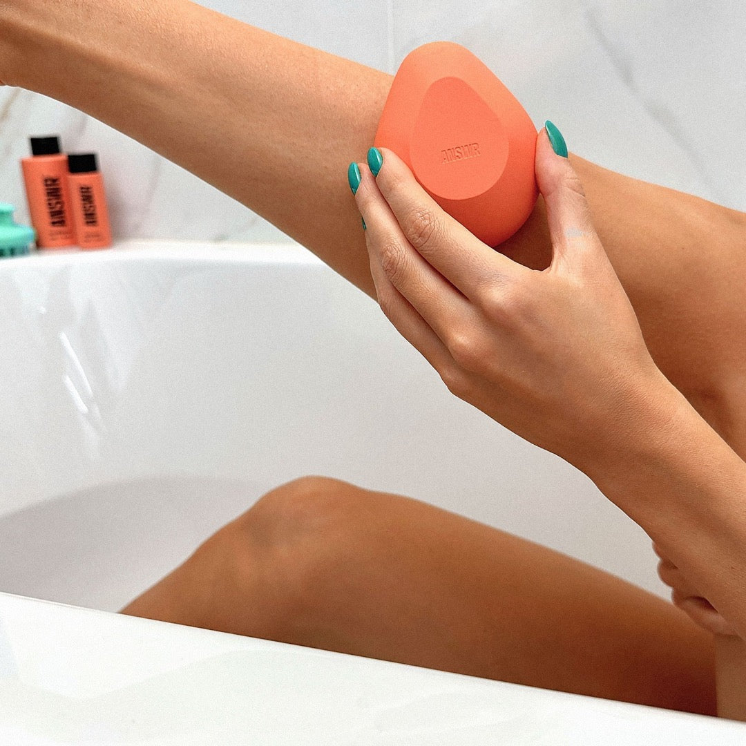 Model holding ANSWR Exfoliating Hair Removal Drop